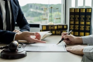 A person questions an item on a clipboard on a desk between two people.