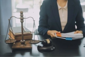 The torso of a personal injury lawyer taking notes at her desk.